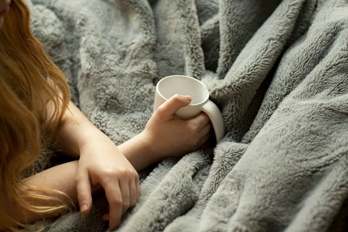 woman holding white ceramic mug