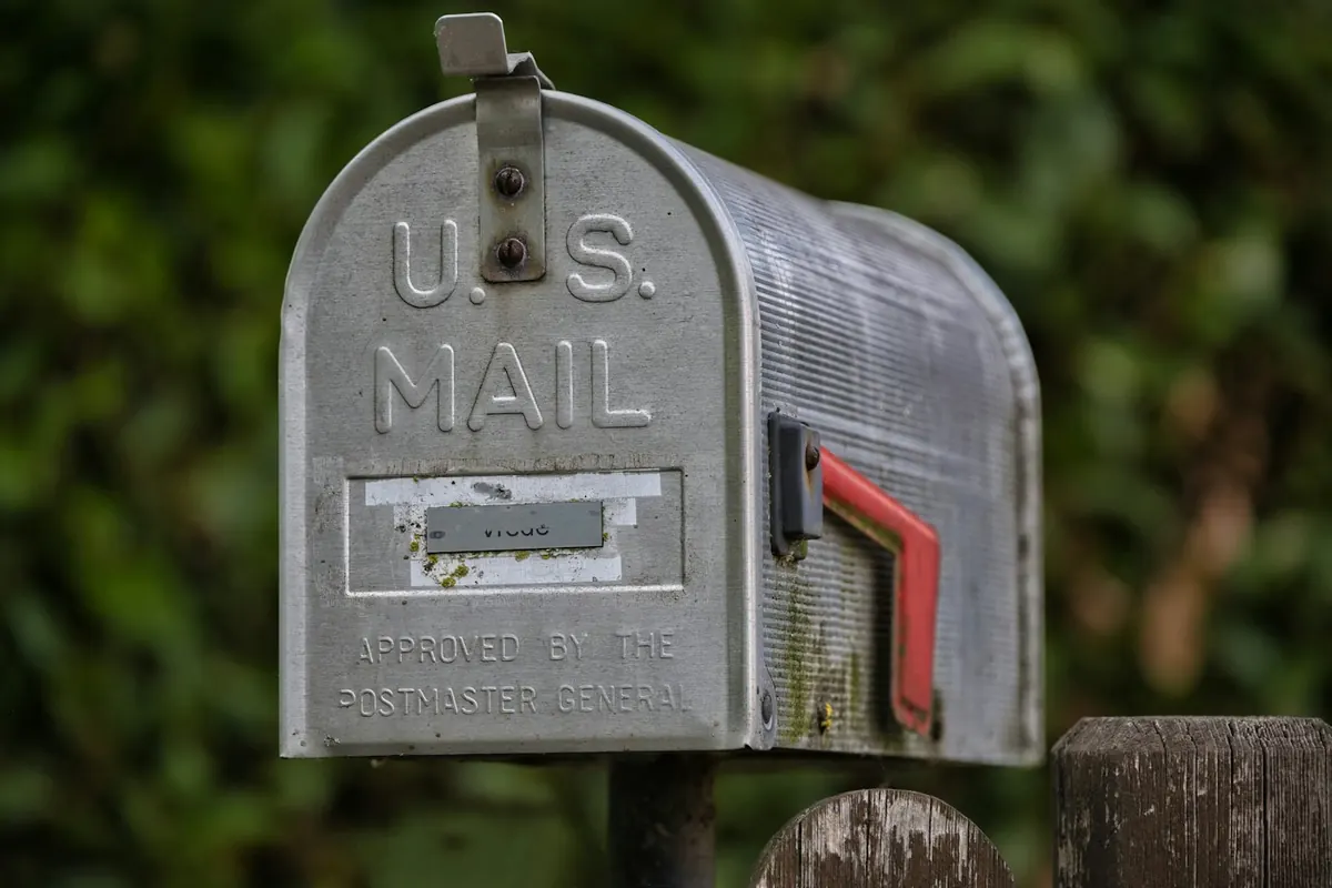 A weathered u.s. mailbox with a red flag