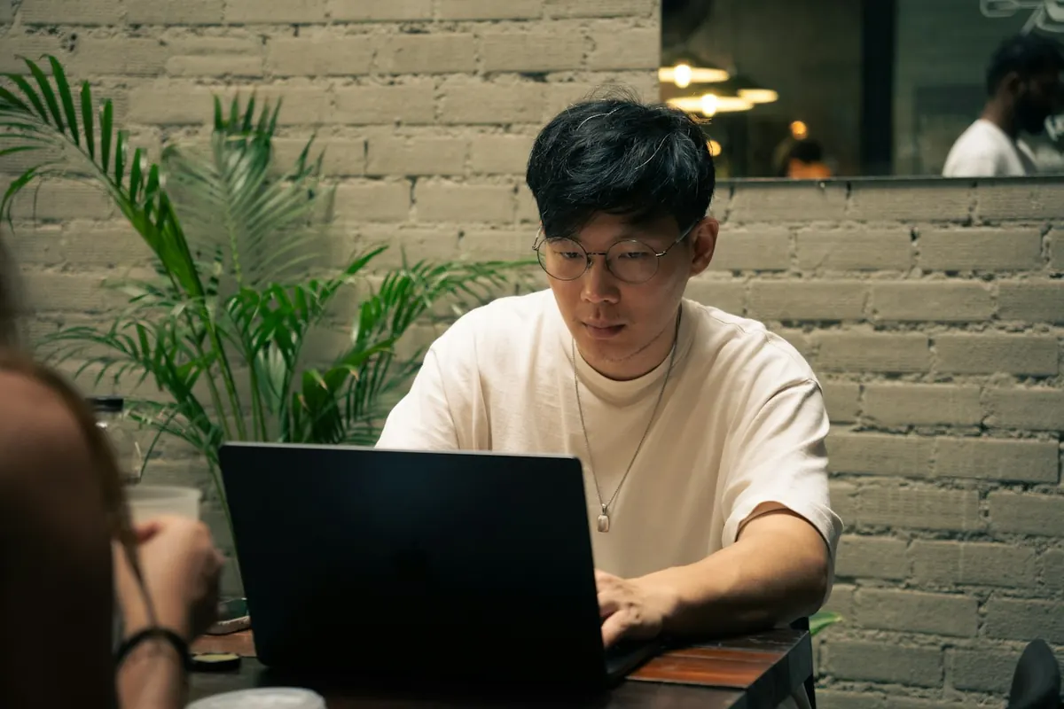 Man works on a laptop at a cafe