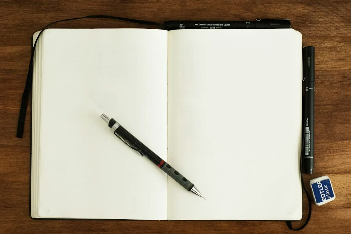 black and silver retractable pen on blank book