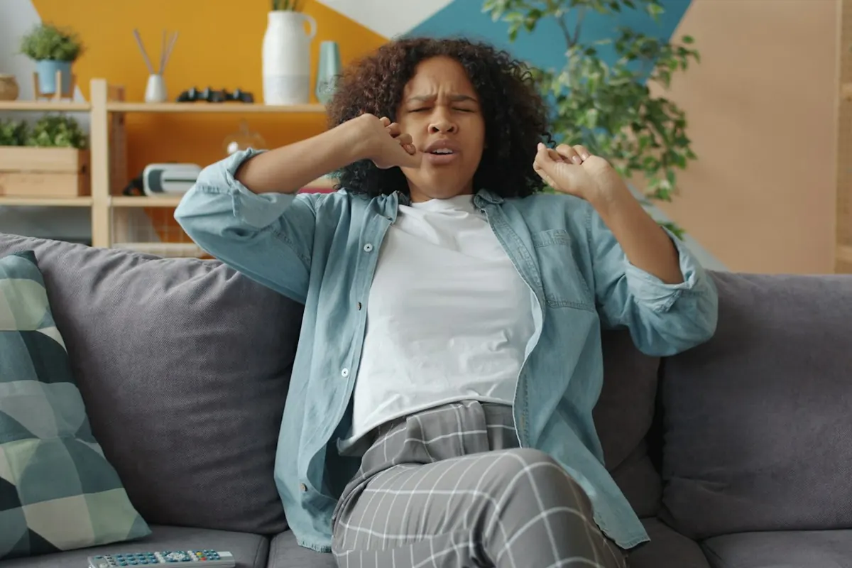 Woman sitting on couch with hands near face